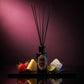 HURRICANE Midnight Sugar reed diffuser: a black bottle with a gold oval label, black reeds and its notes around it.