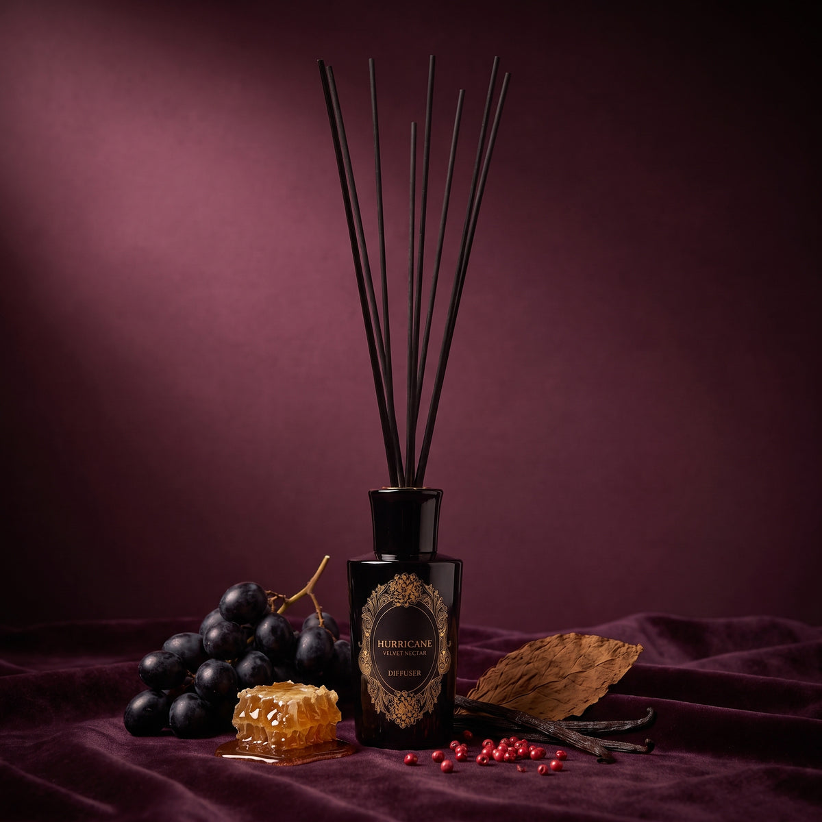 HURRICANE Velvet Nectar reed diffuser: a black bottle with a gold oval label, black reeds and its notes around it.